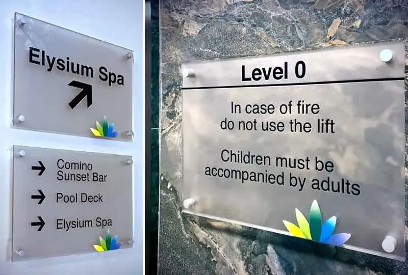 Frosted glass wayfinding signs for Elysium Spa, and a Level 0 fire notice plate on stone