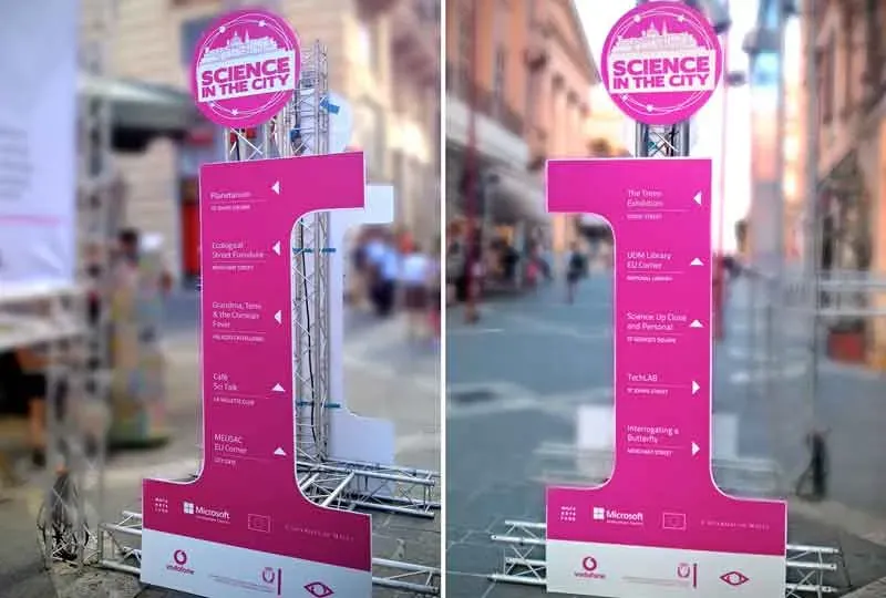 Two printed Science in the City wayfinding totems standing in a Valletta street