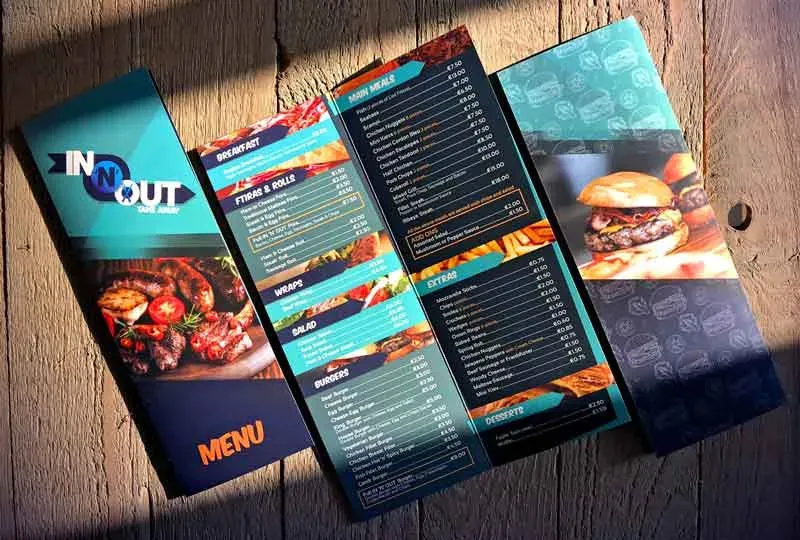 A printed takeaway menu folded open on a weathered wooden table